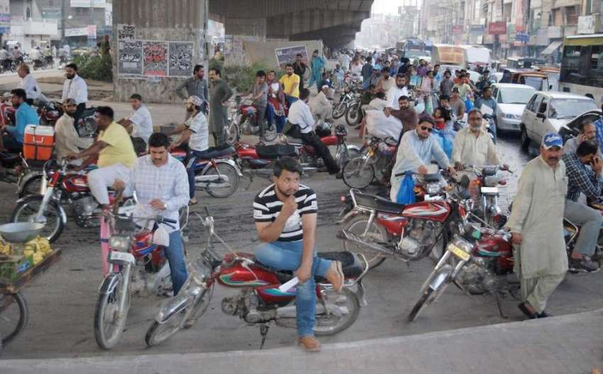 لاہور: مغلپورہ کے علاقہ میں بارش سے بچنے کے لیے موٹر سائیکل ..
