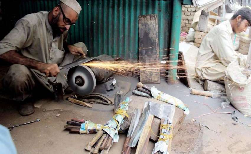پشاور: عید قربان کے لیے ایک دکاندار چھریاں تیز کرنے میں مصروف ..