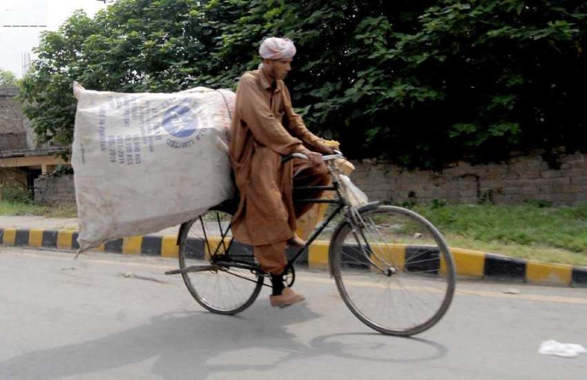 راولپنڈی: ایک محنت کش سائیکل پر سامان لادھے جارہا ہے۔