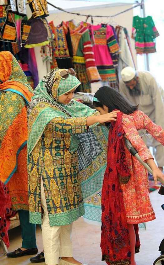 اسلام آباد: ایک خاتون اپنی بچی کے لیے کپڑے پسند کر رہی ہے۔