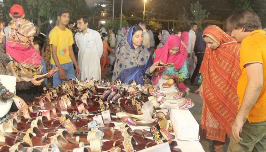 لاہور: لبرٹی مارکیٹ میں خواتین سٹال سے جوتے خریدنے کے لیے ..