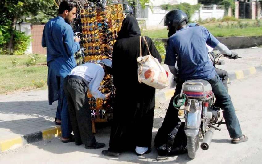 راولپنڈی: ایک فیملی روڈ کنارے دھوپ سے بچاؤ کی عینکیں خرید ..