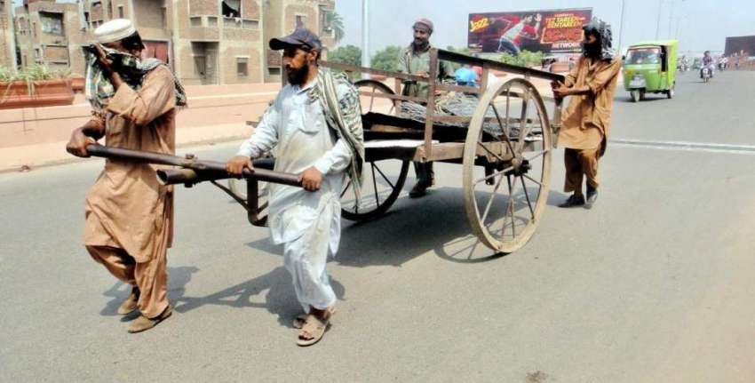 لاہور: محنت کش ہتھ ریڑھی پر لوہے کی چادریں رکھے ہوئے گڑھی ..