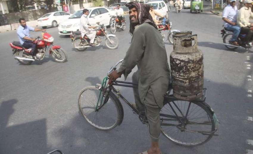 لاہور: ایک شخص بغیر کسی سپورٹ کے گیس سلنڈر سائیکل کے پیچھے ..