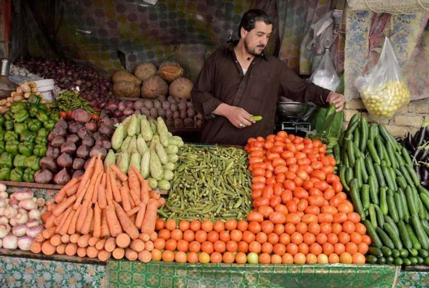 کوئٹہ: سبزی مارکیٹ میں ایک دکاندار خریداروں کو متوجہ کرنے ..
