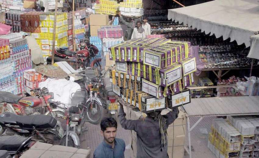 لاہور: مستی گیٹ بازار میں محنت کش بھاری سامان اپنے سروں پر ..