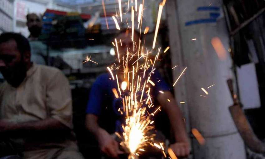 راولپنڈی: عید قربان کے لیے ایک دکاندار چھریاں تیز کر رہا ..