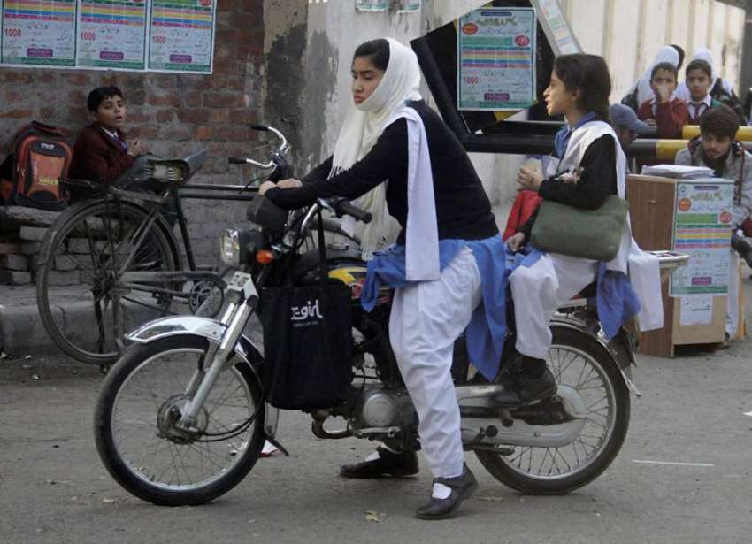 لاہور: ایک طالبہ اپن چھوٹی بہن کے ہمراہ سکول سے چھٹی کے بعد ..