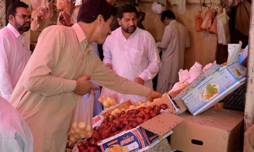 کوئٹہ: سبزی مارکیٹ میں ایک شہری افطاری سے قبل پھل خرید رہا ..