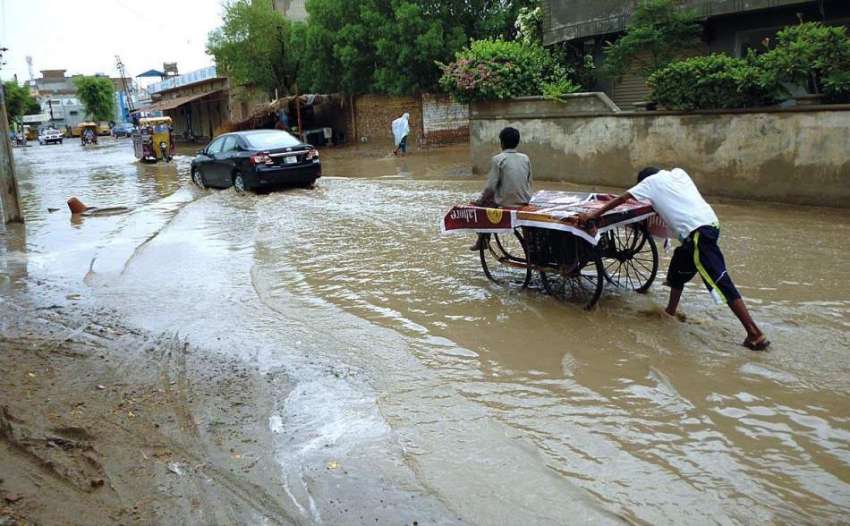 بہاولپور: ایک ریڑھی بان بارش کے پانی میں سے گزر رہا ہے۔
