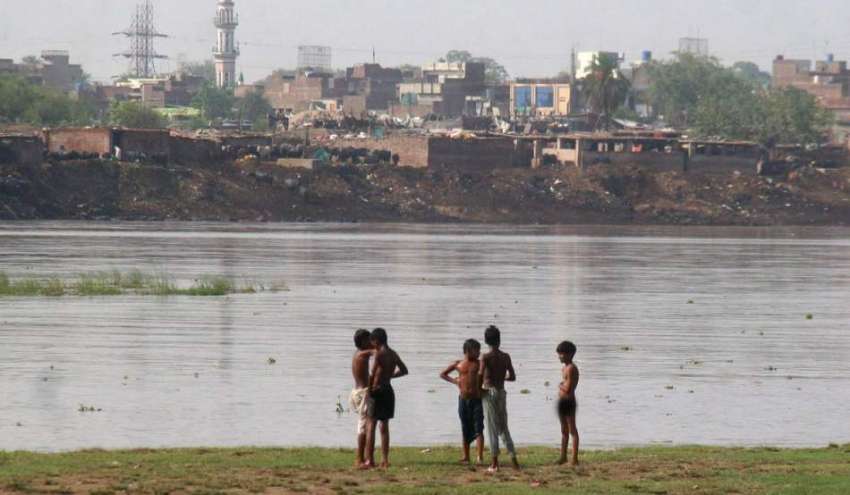 لاہور: خا نہ بدوش بچے نہانے کے لیے دریائے راوی کنارے کھڑے ..