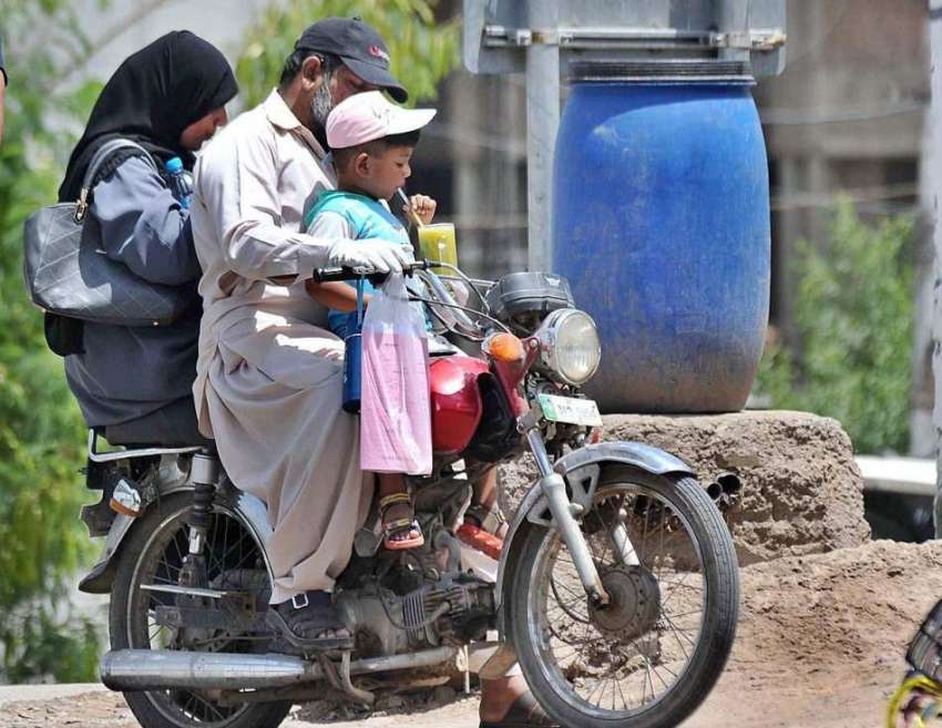 راولپنڈی : موٹر سائیکل سوار فیملی گرمی کی شدت کو کم کرنے ..