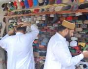 لاہور: شہری مال روڈ پر مسجد شہداء کے باہر ٹوپی خریدنے کے لیے پسند کر ..