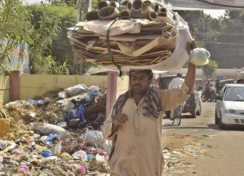 لاہور: ایک شخص گتہ فروخت کرنے کے لیے سر پر اٹھا کر لیجا رہا ..