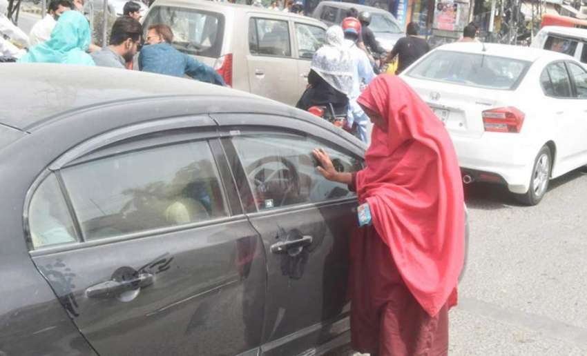 لاہور: ایک خاتون گاڑی واے سے بھیک مانگ رہی ہے۔