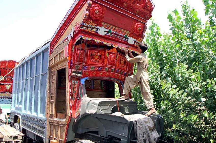 پشاور: محنت کش ٹرک کی تزئین و آرائش کے کام میں مصروف ہے۔