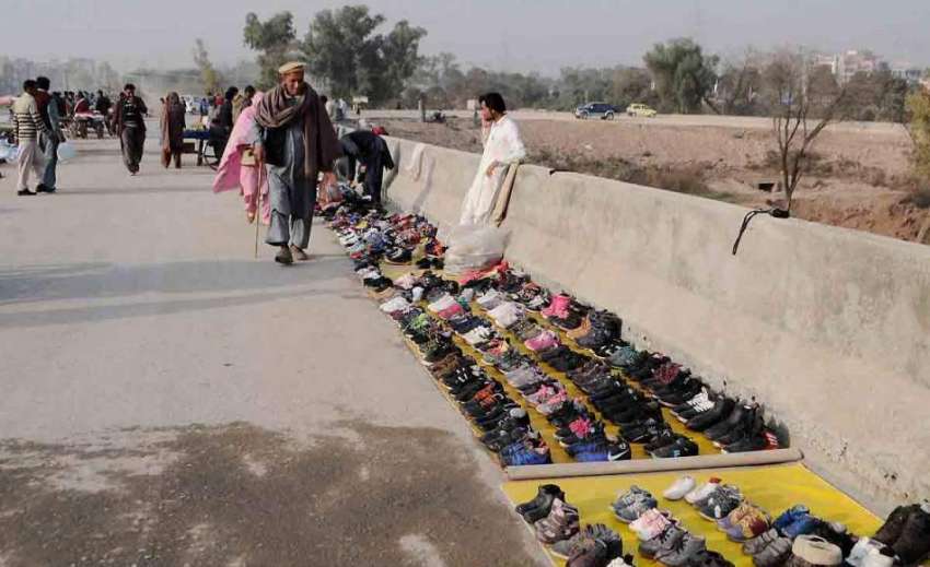 اسلام آباد: کھنہ پل روڈ کنارے محنت کش جوتے سجائے گاہکوں کا ..
