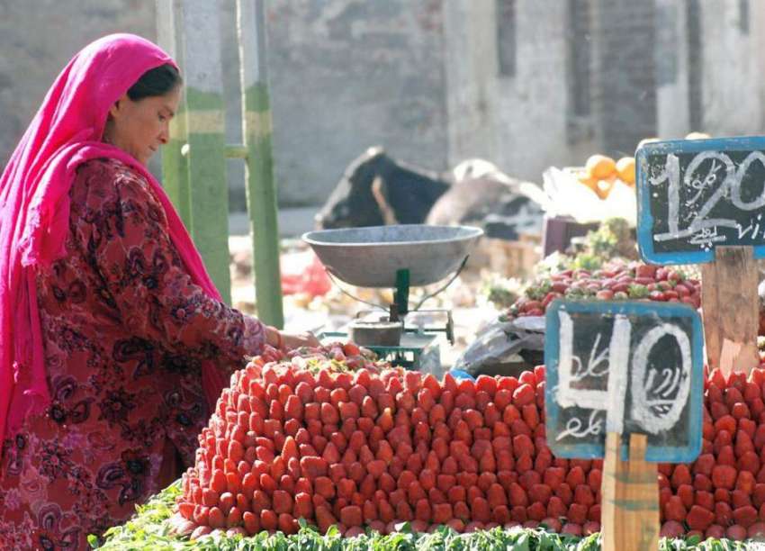 لاہور: ایک محنت کش خاتون گاہکوں کو متوجہ کرنے کے لیے اسٹرابری ..