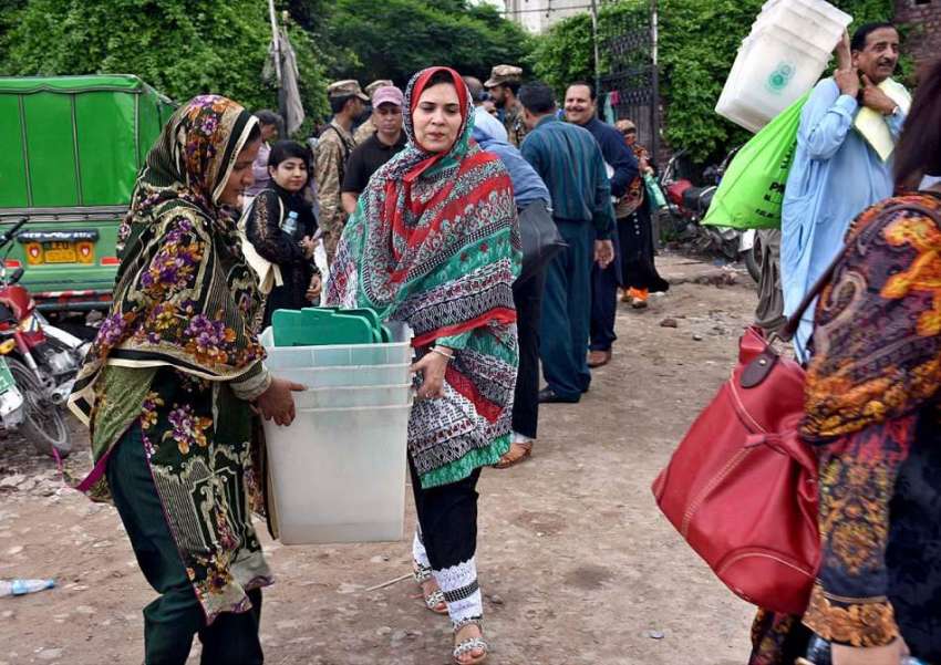 لاہور: خواتین پریزائیڈنگ آفیسران پولنگ کا سامان لیجا رہی ..