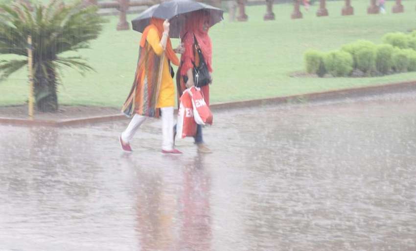 لاہور: شاہی قلعہ میں سیرو تفریح کے لیے آئی خواتین بارش سے ..