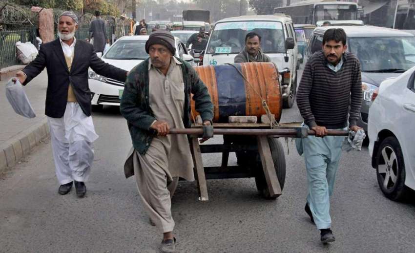 لاہور: محنت کش ہتھ ریڑھی پر ڈرم رکھے جارہے ہیں۔