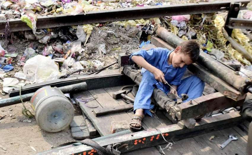 لاہور: ایک خانہ بدوش بچہ اپنے ریڑھے کی مرمت میں مصروف ہے۔