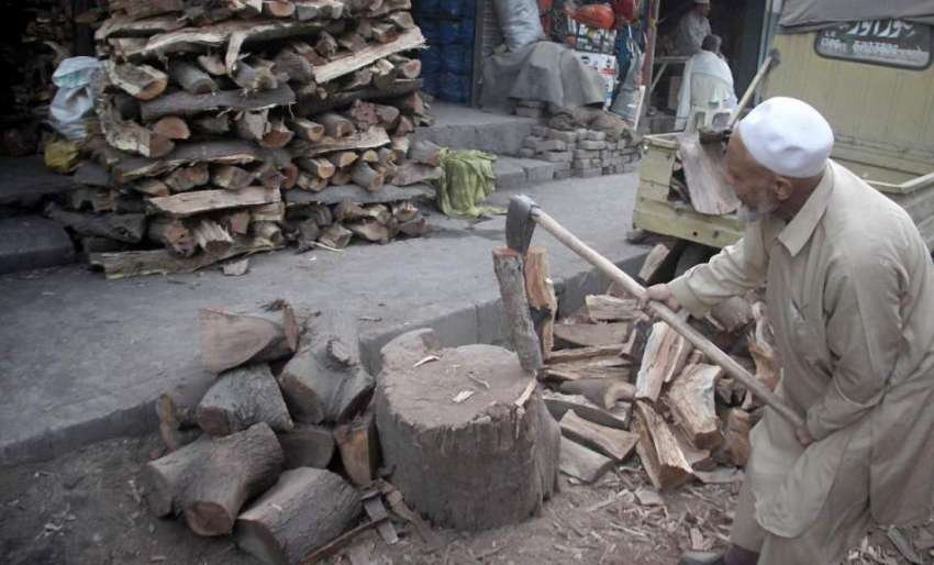 لاہور: ایک بزرگ لکڑیاں کاٹ رہا ہے، سوئی گیس پریشر میں کمی ..