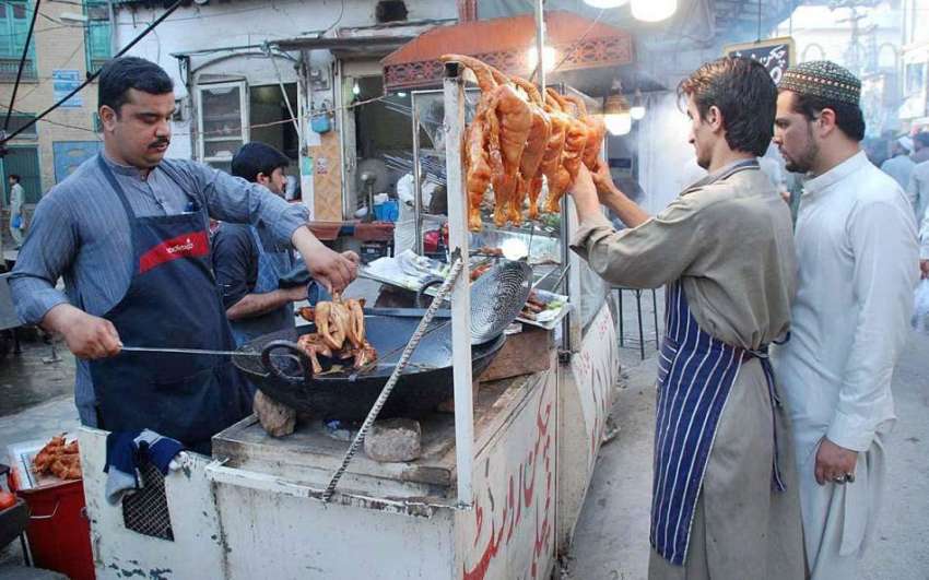 پشاور: دکاندار سڑک کنارے سٹال لگائے چکن فروخت کے لیے فرائی ..