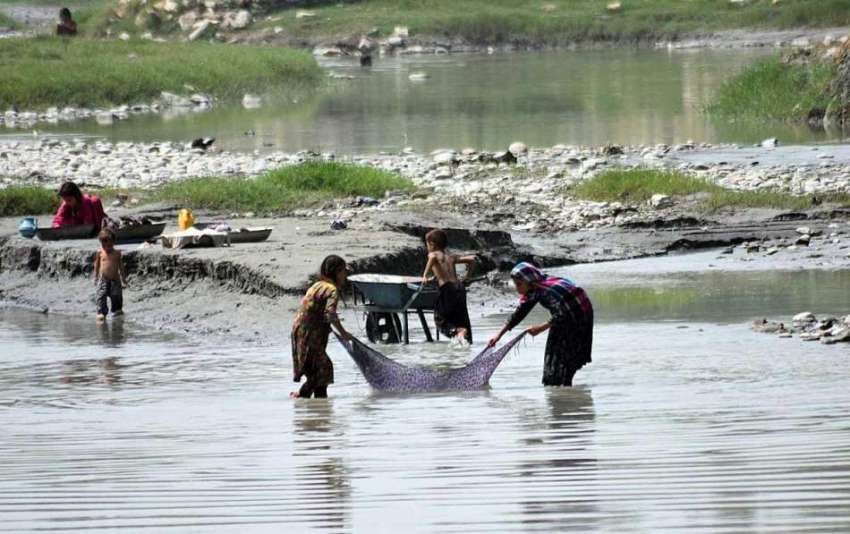 پشاور: خانہ بدش بچے خزانہ کیمپ کے علاقہ میں کپڑے دھو رہے ..