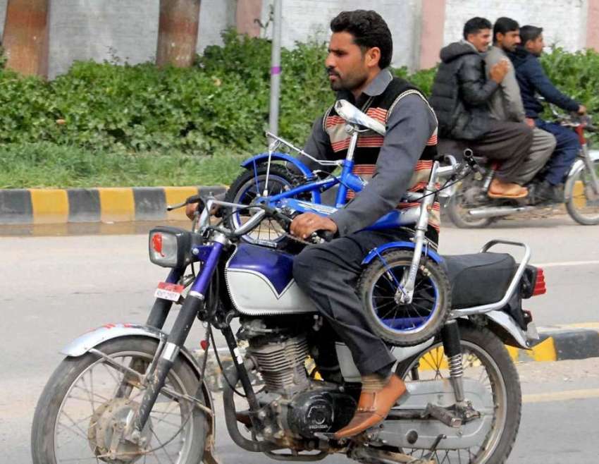 راولپنڈی: موٹر سائیکل سوار سائیکل اٹھائے بائیک چلا رہا ہے ..