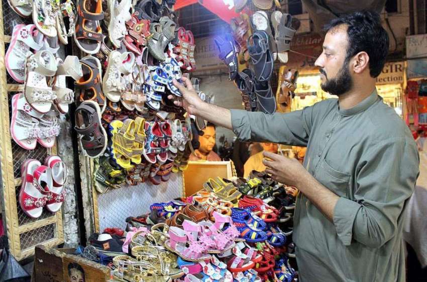 پشاور: دکاندار گاہکوں کو متوجہ کرنے کے لیے بچوں کے جوتے سجا ..