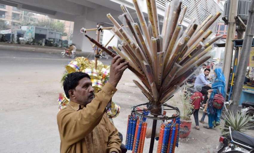 لاہور: ایک شخص بانسریاں فروخت کررہا ہے۔