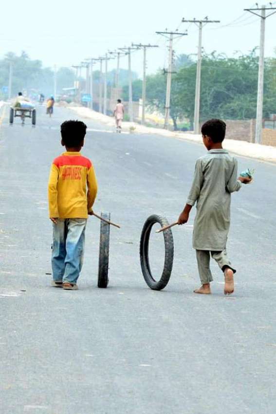 ملتان: دو بچے موٹر سائیکل کے ٹائروں سے کھیل رہے ہیں۔