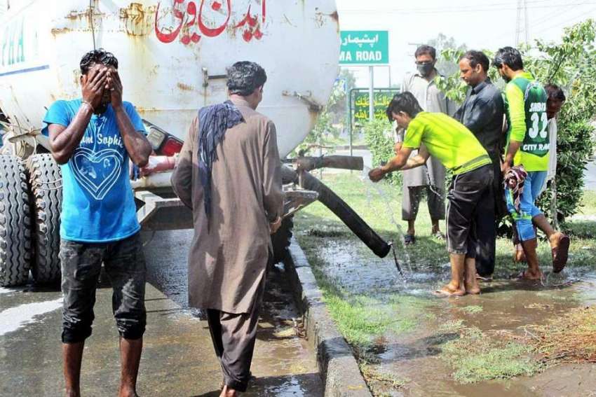 فیصل آباد: شہری گرمی کی شدت کم کرنے کے لیے منہ پر پانی کے ..