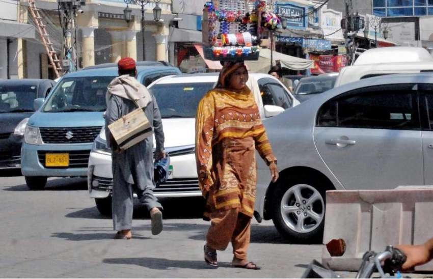 راولپنڈی: صدر بازار میں ایک محنت کش خاتون سر پر جیولری رکھے ..