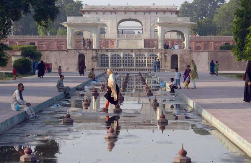 لاہور: ایک خاتون شالیمار باغ میں لگے بند فواروں کے اندر سے ..