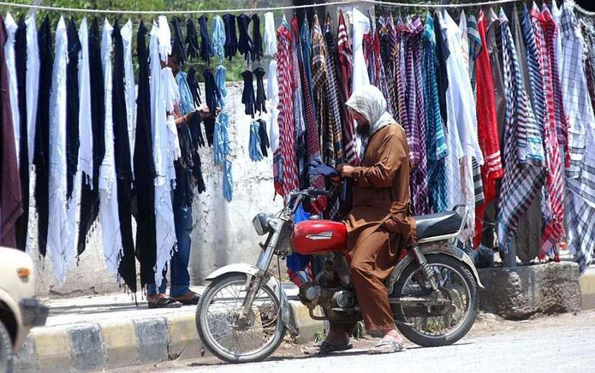 راولپنڈی: موٹر سائیکل سوار سڑک کنارے لگے سٹال سے رومال پسند ..