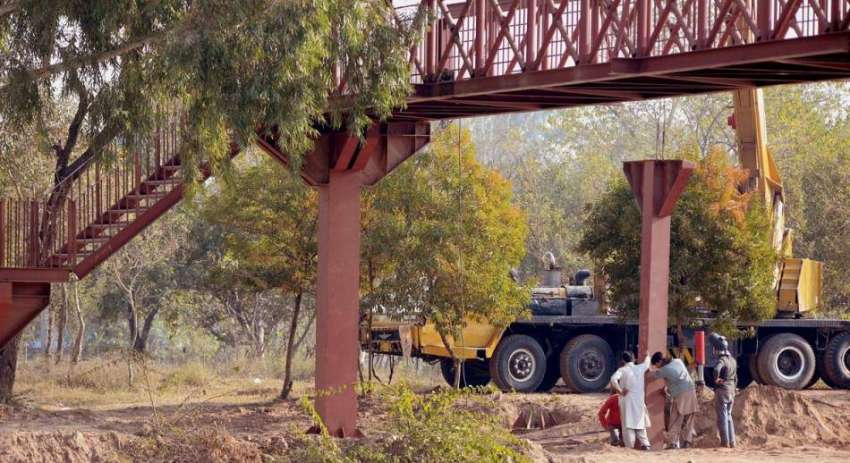 راولپنڈی: مزدور پیدل سڑک کراس کرنے کے پل نصب کررہے ہیں۔
