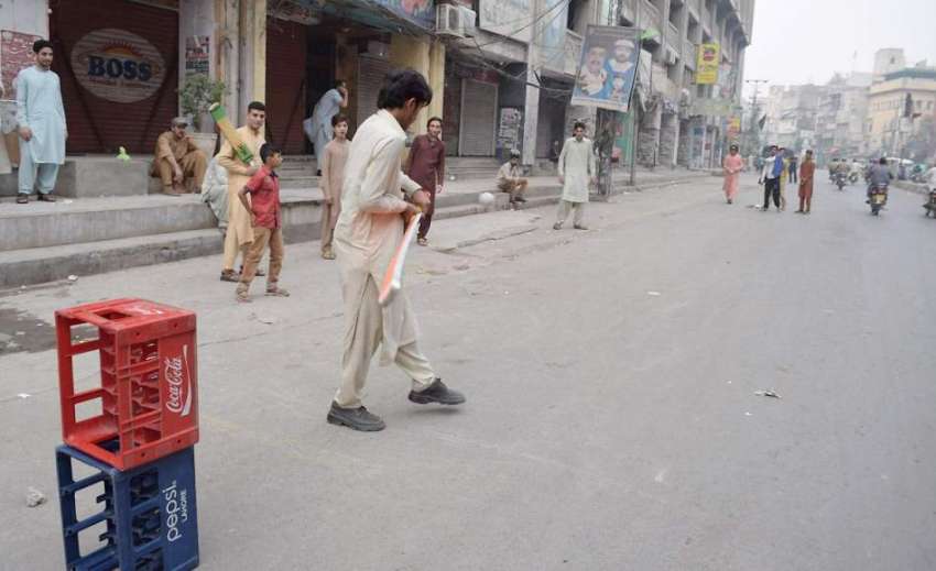 لاہور: نوجوان سڑک پر کرکٹ کھیل رہے ہیں۔