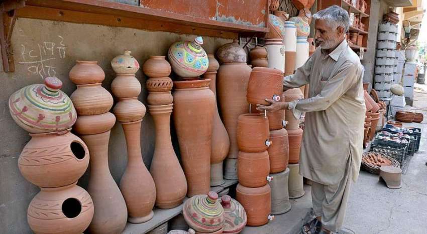 راولپنڈی: ایک معمر محنت کش گاہکوں کو متوجہ کرنے کے لیے مٹی ..
