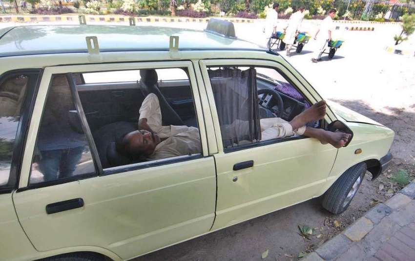 راولپنڈی: ٹیکسی ڈرائیور کام نہ ہونے کے باعث آرام کر رہا ہے۔