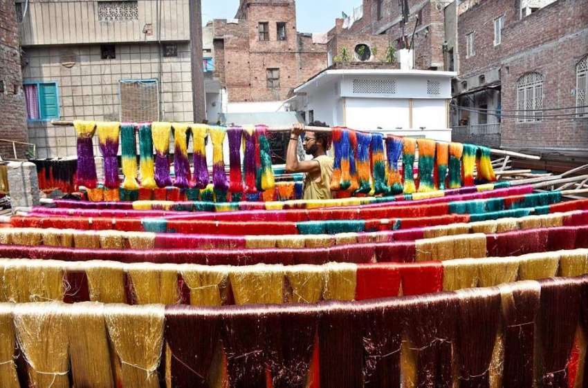 لاہور: رنگساز کپڑے خشک کرنے کے لیے دھوپ میں پھیلا رہا ہے۔