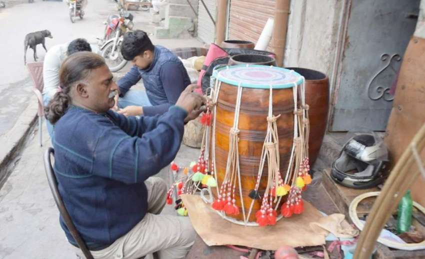 لاہور: ٹبی سٹی بازار میں ایک کاریگر ڈھول تیار کررہا ہے۔