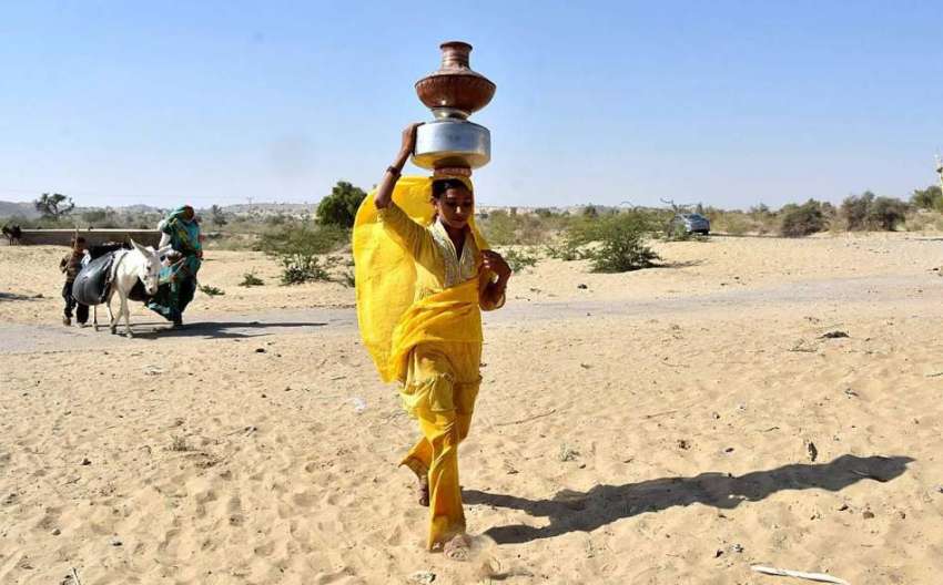 تھرپارکر: خاتون کنویں سے پینے کا پانی بھرکر لیجا رہی ہے۔