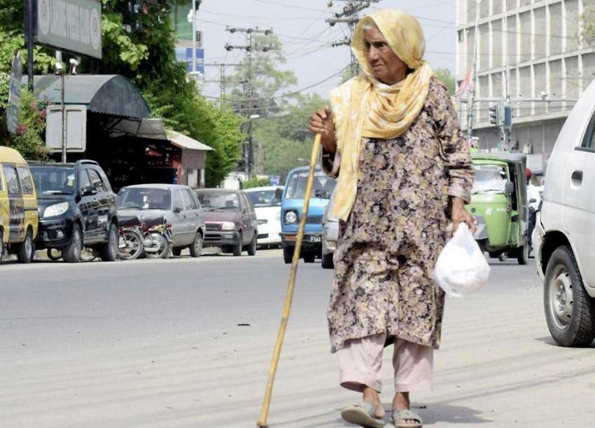 لاہور: ایک معمر خاتون پریس کلب ک سامنے سے گزر رہی ہے۔