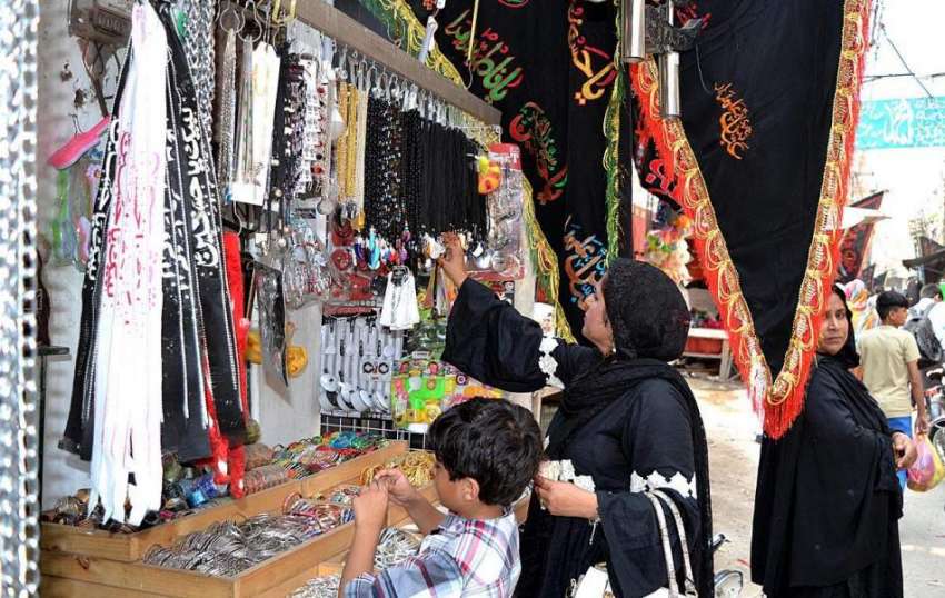 لاہور: خواتین ایک دکان سے محرم الحرام کے حوالے سے سجائی گئی ..