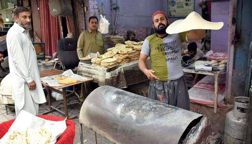 پشاور: فوارہ چوک فوڈ سٹریٹ میں ایک شخص روٹیاں پکا رہا ہے۔