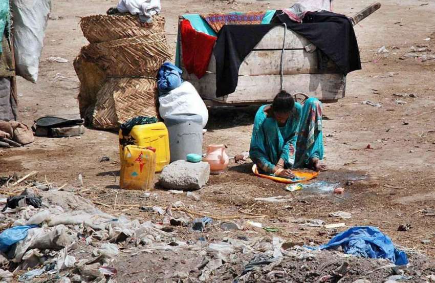 پشاور: خانہ بدوش خاتون کپڑے دھو رہی ہے۔