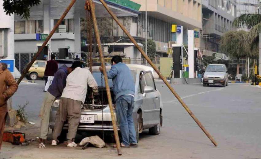 اسلام آباد: مکینک روڈ کنارے گاڑی کے انجن کی تیاری میں مصروف ..