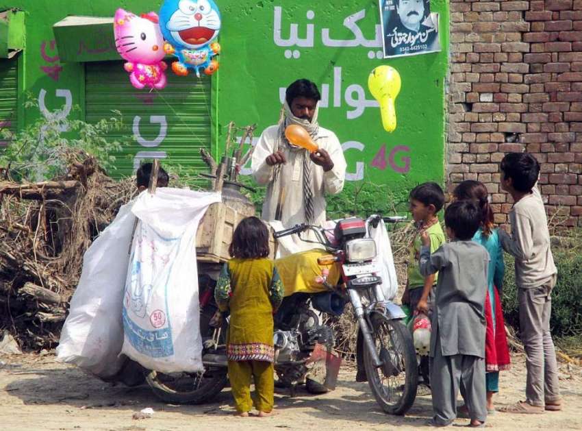 فیصل آباد: محنت کش غبارے فروخت کر رہا ہے۔